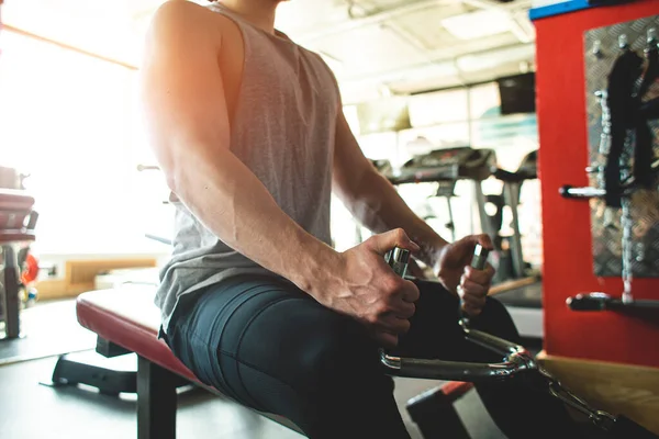 Un jeune homme s'entraîne au gymnase. Exercices de force sur le simulateur — Photo