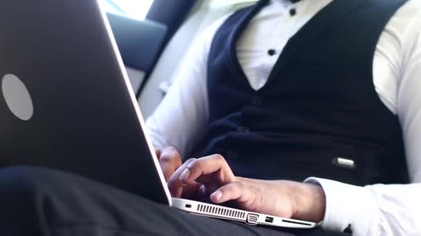Indiska affärsman arbetar med bärbar dator i baksätet på bilen. Närbild av händer — Stockvideo