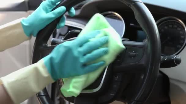 Mãos limpe o volante de um carro de poeira e manchas com um pano especial close-up — Vídeo de Stock