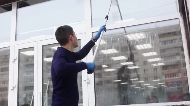 Un profesional de limpieza de ventanas jabones y exfoliantes una ventana limpia, trabajador de limpieza masculina. — Vídeos de Stock