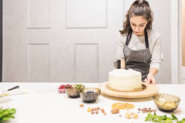 Şekerleme spatulası ile bisküvi pastası üzerine beyaz krema. Ev yapımı hamur işi, kek pişirme....