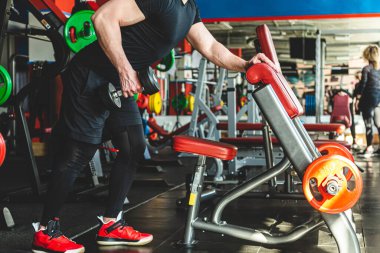 Spor salonunda dambıllarla antrenman. Dayanıklılık egzersizleri.