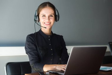 Kadın müşteri hizmetleri çalışanı portresi, çağrı merkezi gülümseyen operatör ve ofis telefonu.