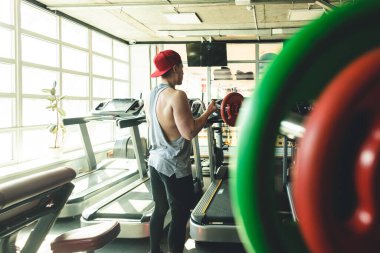 Spor salonunda genç ve kaslı bir sporcunun güçlü eğitimi..