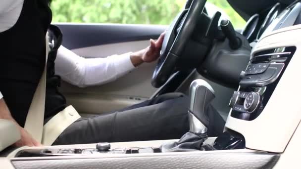Чоловік застібає ремінь безпеки під час водіння. Крупним планом — стокове відео
