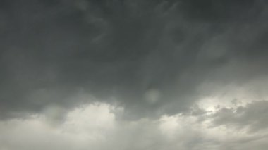 Fırtınalı hava ve bulutlu. Gökyüzünde gök gürültülü bulutlar süzülür ve lenslerde yağmur damlaları