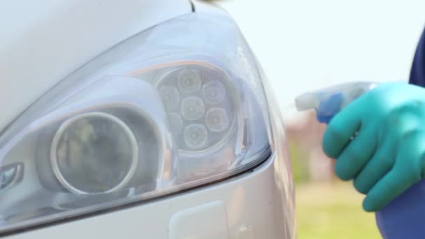 Καθαρισμός αυτοκινήτων. Ένας άντρας με γάντια καθαρίζει τους προβολείς του αυτοκινήτου και σκουπίζει για να λάμψει.. — Αρχείο Βίντεο