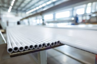 Polipropilen boru deposu. Plastik boru üretmek için ekstrakarların olduğu bir atölye. Su tedarik ve gaz borularından yüksek hızda ekstrüzyon hattı. Üretim tesisi.