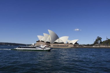 Sydney Opera Binası waterraglan sahilden günbatımında küçük dalgalar ile görüntülendi.