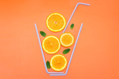 Portakal dilimlerinden, taze nane yapraklarından ve parlak turuncu arka planda kokteyl pipetlerinden oluşan yaratıcı düz bir yapı. Ferahlatıcı ve sulu yaz içeceği tarifi konsepti. Boşluğu kopyala, canlı renkler.