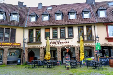 Hattingen, Almanya - 14 Haziran 2025: Hattingen 'de açık hava oturma ve şemsiyelerin yer aldığı tarihi bina cephesi.