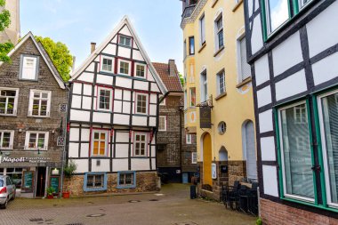 Hattingen, Almanya - 14 Haziran 2025: Almanya 'nın Hattingen kentindeki tuhaf bir kaldırım taşı meydanında yarı keresteli evler ve modern mimari büyüleyici.
