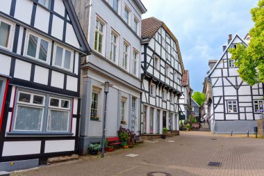 Hattingen, Almanya - 14 Haziran 2025: Paved caddesi Hattingen, Almanya 'da geleneksel yarı keresteli evler ve yeşilliklerle dolu.