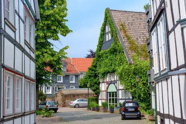 Hattingen, Almanya - 14 Haziran 2025: Hattingen 'de yeşil ağaçlarla süslenmiş geleneksel sokak manzarası.