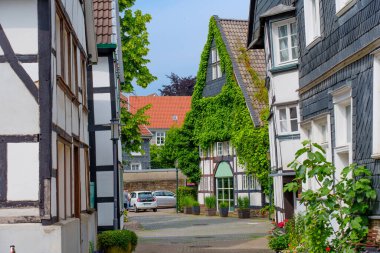 Hattingen, Almanya - 14 Haziran 2025: Hattingen, Almanya 'da yarı keresteli evler ve yeşilliklerle dolu dar bir sokak, Avrupa' nın pitoresk bir yapısını gözler önüne seriyor.