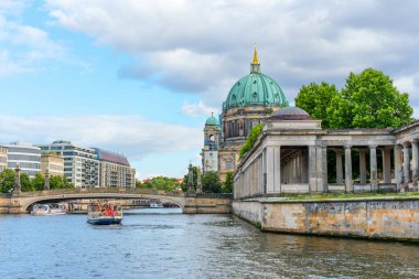 Berlin, Almanya - 17 Ağustos 2025: Berlin Katedrali 'nin yeşil kubbesi Spree Nehri' ne bulutlu bir gökyüzünün altında yansıtılan manzarası.