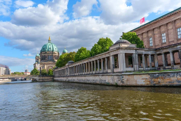 Berlin, Almanya - 17 Ağustos 2025: Spree Nehri kıyısındaki Berlin Katedrali 'nin panoramik manzarası tarihi binalar ve parçalı bulutlu bir gökyüzü altında yemyeşil.