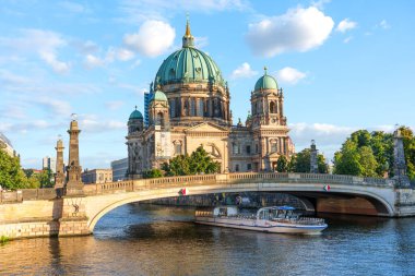 Berlin, Almanya - 17 Ağustos 2025: Parlak mavi gökyüzü altında yeşil kubbesi ve nehir manzarasının yer aldığı Berlin Katedrali 'nin çarpıcı manzarası.