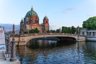 Berlin, Almanya - 17 Ağustos 2025: Önünde süslü bir köprü bulunan Berlin Katedrali manzarası, Spree Nehri 'ne altın saat boyunca yansıyor.