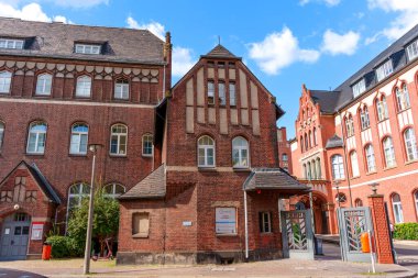 Berlin, Almanya - 17 Ağustos 2025: Açık mavi gökyüzü ve tarihsel mimariye sahip karmaşık detayları içeren eski tuğla bina.