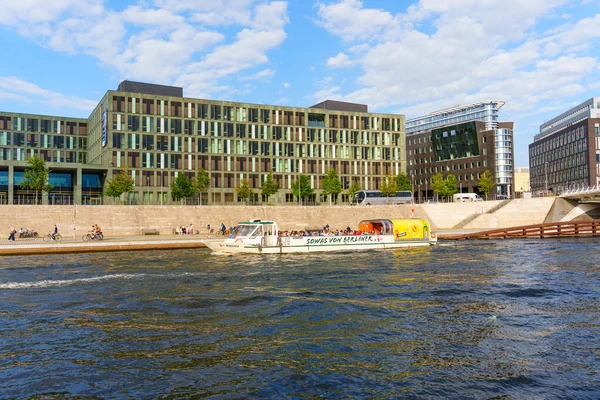 Berlin, Almanya - 20 Ağustos 2025: Güneşli bir günde modern binalarla Spree Nehri 'nde tekne turu.