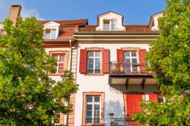 Stunning view of traditional German architecture featuring red shutters, located in the picturesque city of Heidelberg under clear blue skies.