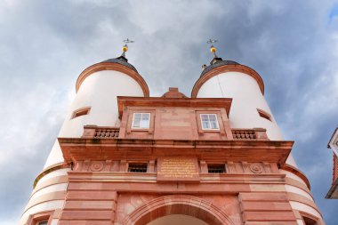 Heidelberg, Almanya - 8 Haziran 2025: Heidelberg, Almanya 'daki tarihi kapı evinin yakın görüntüsü, karamsar bir gökyüzü altında ikiz kulelerin ve dekoratif mimari detayların yer aldığı.