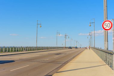 Mainz, Almanya - 19 Haziran 2025: Mainz köprüsünün geniş açılı görüntüsü iyi korunmuş bir yol, açık mavi gökyüzü ve trafik işaretleri, araçlar ve bisikletçiler uzayda geziniyor.