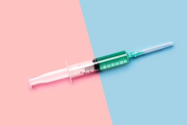 Büyük 10 ml plastik şırınga ile stüdyo ışık yukarıdan çekim parlak pembe ve mavi zemin üzerine parlak yeşil sıvı ile