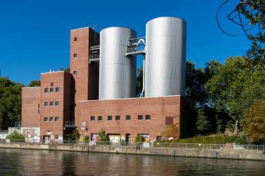 Berlin, Almanya - 30 Eylül 2018: Görünümü üzerinde Charlottenburg enerji santrali (Kraftwerk Charlottenburg) nehrin binalar duvarlarda grafiti yanında duran insanlar bir çift ile ters tarafındaki