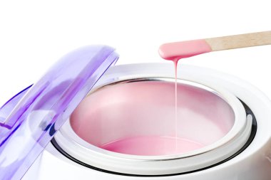Yakın çekim sıcak pembe balmumu ve tahta bir spatula ile balmumu ısıtıcı