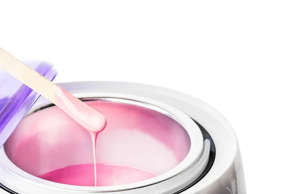 Yakın çekim sıcak pembe balmumu ve tahta bir spatula ile balmumu ısıtıcı