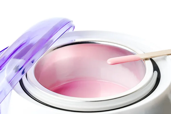 Yakın çekim sıcak pembe balmumu ve tahta bir spatula ile balmumu ısıtıcı
