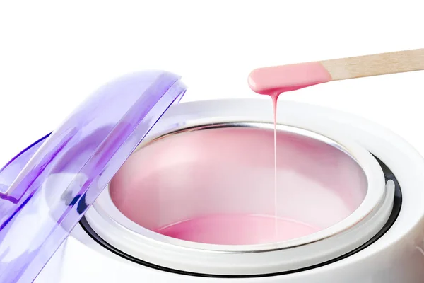 Yakın çekim sıcak pembe balmumu ve tahta bir spatula ile balmumu ısıtıcı