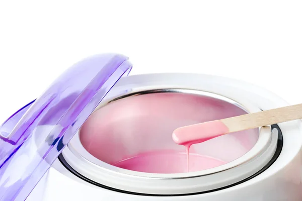Yakın çekim sıcak pembe balmumu ve tahta bir spatula ile balmumu ısıtıcı