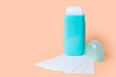 Açık deniz mavisi roll-on sıcak balmumu ısıtıcı ve kağıt şeritler turuncu zemin üzerine