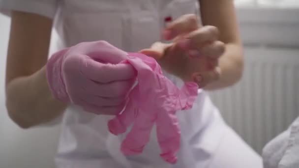 化粧品の女の子は クリーニングや顔のマッサージの手順の前にピンクの手袋を着用しています 全身の穏やかでリラクゼーション — ストック動画