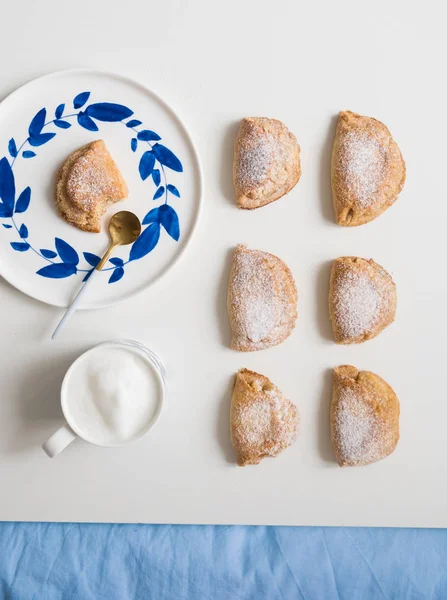 Mavi tabaklarda lezzetli ev yapımı tatlı. Beyaz bir kupa kahve ile Shortbread tatlı. çay kaşığı altın. Yaprak küpeli tabak. Beyaz arka planda.
