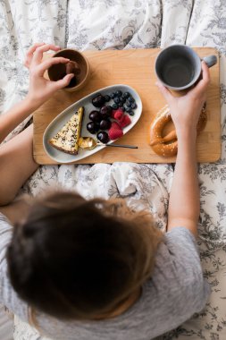 Sıcak bir yatakta tembel bir sabah. Güzel ve güzel bir kız rahat bir atmosferde kışın, odasında sabah kahvaltı vardır. Taze çilek ve çay sıcak bir fincan ile kek tatlı bir parça yeme.