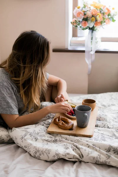 Sıcak bir yatakta tembel bir sabah. Güzel ve güzel bir kız rahat bir atmosferde kışın, odasında sabah kahvaltı vardır. Taze çilek ve çay sıcak bir fincan ile kek tatlı bir parça yeme.