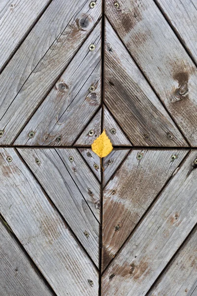 Ahşap arka planda sarı yapraklar. Sonbaharın renkleri ve ruh hali. Yukarıdan görüntüleyin. Üstte görüntü.