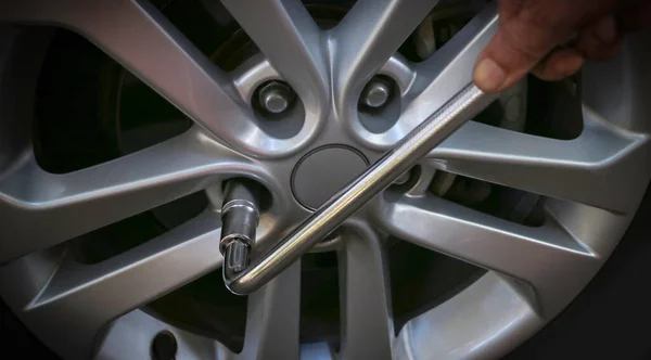 Tamirci el, araba tekerleğini değiştirme, araba bakım servisi, araba çarkını tamir etme, seçici odaklanma, araba tekerleği konseptini kurma.