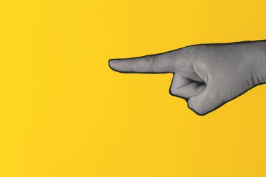 Parlak sarı arka planı gösteren kadın eli.