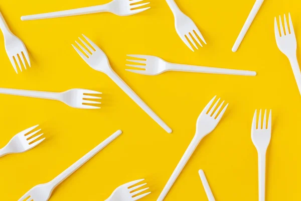 Forcelle in plastica bianca su fondo giallo. Flatlay . — Foto Stock