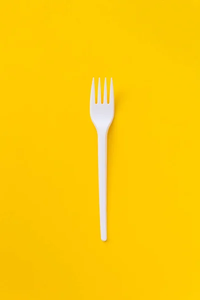 Forcella in plastica bianca su fondo giallo vibrante . — Foto Stock