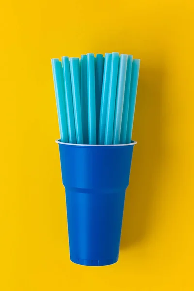 Plastic beker met veel blauwe drink rietjes. — Stockfoto