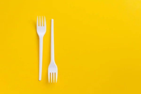 Forcelle in plastica bianca su fondo giallo. Flatlay . — Foto Stock