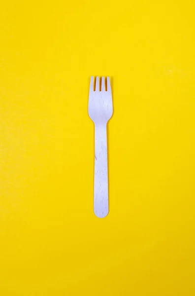 Una forchetta di legno su sfondo giallo vibrante . — Foto Stock