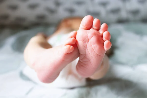 Acercamiento rosa tacones recién nacidos en la cama . — Foto de Stock