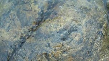 Ladoga gölünde su bulutlu bir günde kıyı taşlarını yıkıyor..